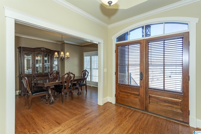 foyer featuring hardwood / wood-style floors, crown molding, and a notable chandelier