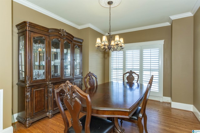 dining space featuring a chandelier, crown molding, and wood-type flooring