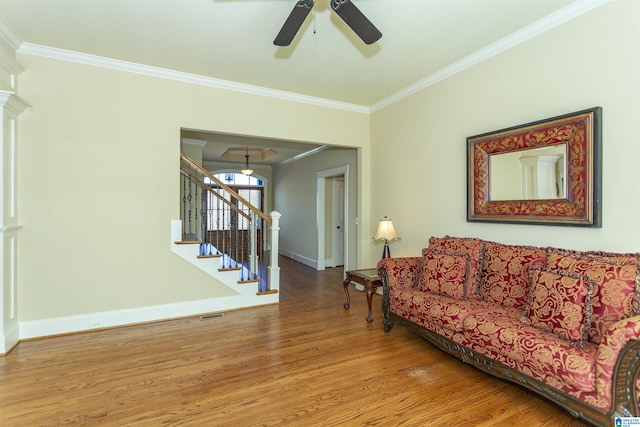 living room featuring ceiling fan, wood-type flooring, and ornamental molding