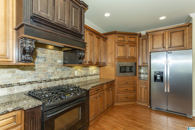 kitchen featuring stone counters, backsplash, light wood-type flooring, stainless steel appliances, and ornamental molding