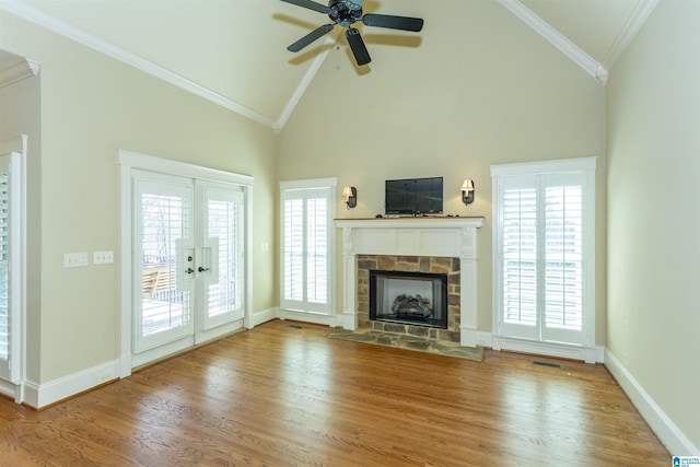 unfurnished living room with wood-type flooring, high vaulted ceiling, crown molding, and a fireplace