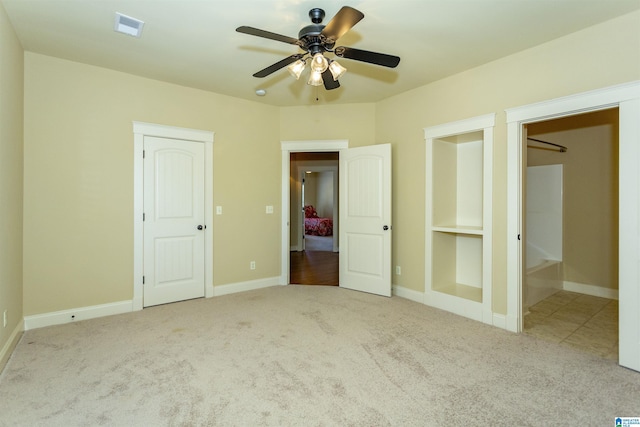 unfurnished bedroom featuring light carpet and ceiling fan