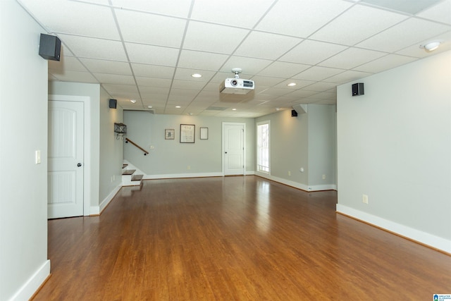 unfurnished living room with a paneled ceiling and dark hardwood / wood-style floors