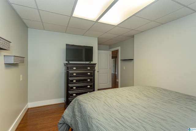 bedroom featuring hardwood / wood-style flooring and a drop ceiling