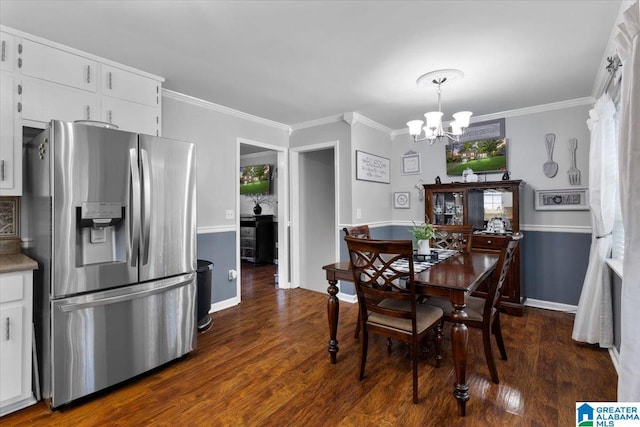 dining area with crown molding, dark hardwood / wood-style floors, and an inviting chandelier