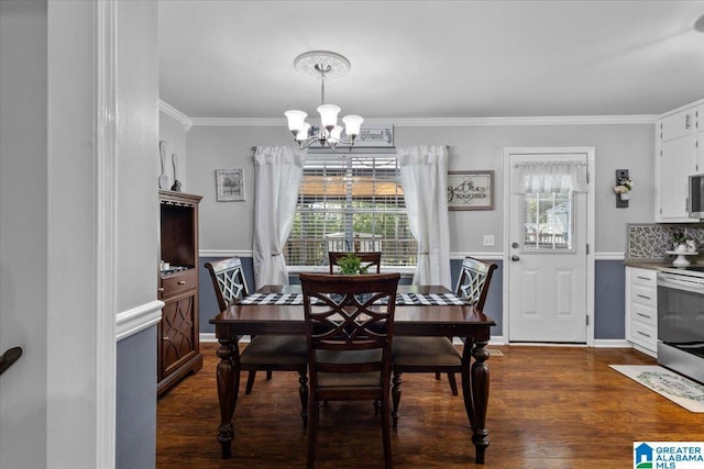 dining space with dark hardwood / wood-style flooring, crown molding, and a chandelier