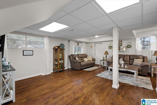 living room featuring a healthy amount of sunlight, a paneled ceiling, and dark hardwood / wood-style flooring