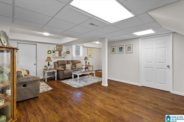 living room featuring dark hardwood / wood-style floors and a paneled ceiling