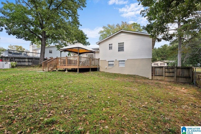 rear view of property with a gazebo, a yard, and a wooden deck