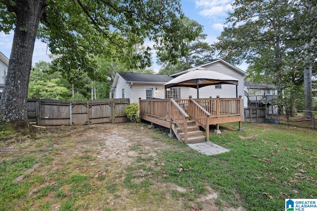 back of property with a gazebo, a lawn, and a deck