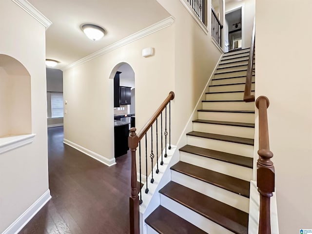 stairs featuring crown molding and hardwood / wood-style floors