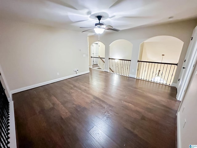 empty room with dark wood-type flooring and ceiling fan