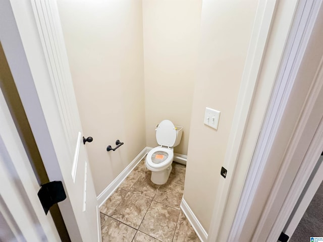 bathroom with toilet and tile patterned flooring