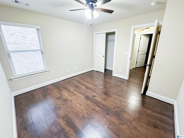 unfurnished bedroom featuring dark wood-type flooring, ceiling fan, and a closet