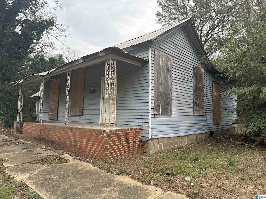 view of side of home featuring covered porch