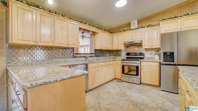 kitchen with stainless steel appliances, sink, light brown cabinets, and light stone counters