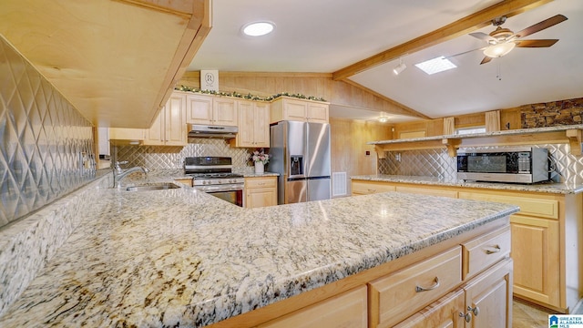 kitchen featuring sink, light stone counters, lofted ceiling with beams, light brown cabinets, and appliances with stainless steel finishes