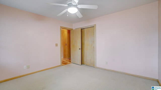 unfurnished bedroom featuring ceiling fan, light colored carpet, and a closet