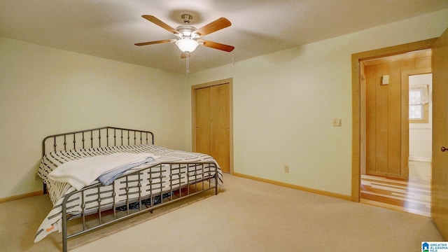 carpeted bedroom featuring ceiling fan and a closet