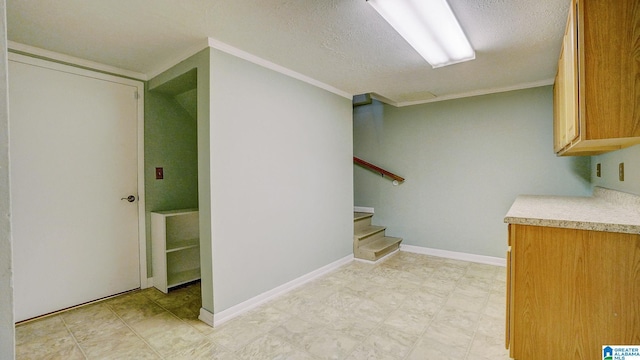 interior space with ornamental molding and a textured ceiling