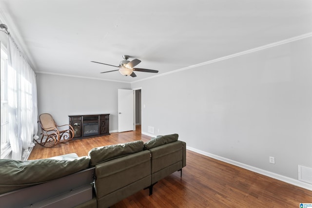 living room with hardwood / wood-style flooring, ornamental molding, and ceiling fan