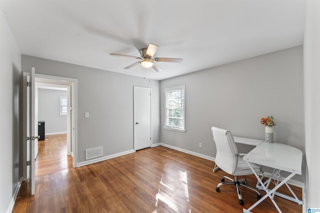 home office with wood-type flooring, a healthy amount of sunlight, and ceiling fan