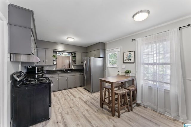 kitchen featuring sink, gray cabinetry, stainless steel appliances, crown molding, and light wood-type flooring