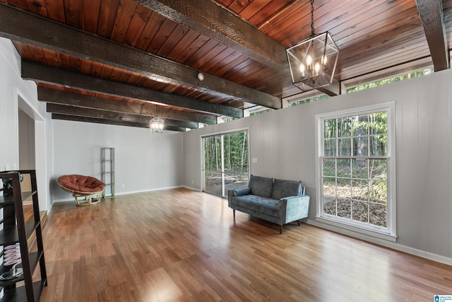 unfurnished room with beamed ceiling, a notable chandelier, hardwood / wood-style floors, and wooden ceiling