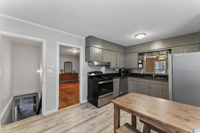 kitchen with sink, gray cabinetry, crown molding, light hardwood / wood-style flooring, and stainless steel appliances