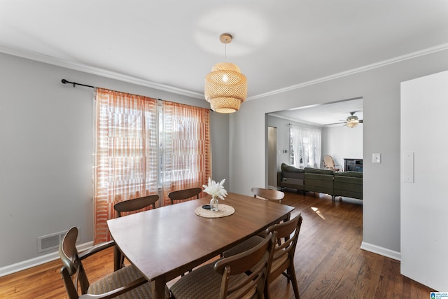 dining area featuring crown molding, ceiling fan, and dark hardwood / wood-style floors