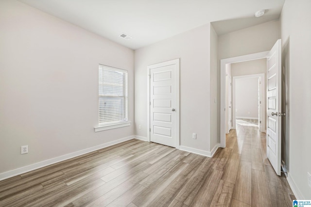 unfurnished bedroom featuring light hardwood / wood-style flooring and a closet