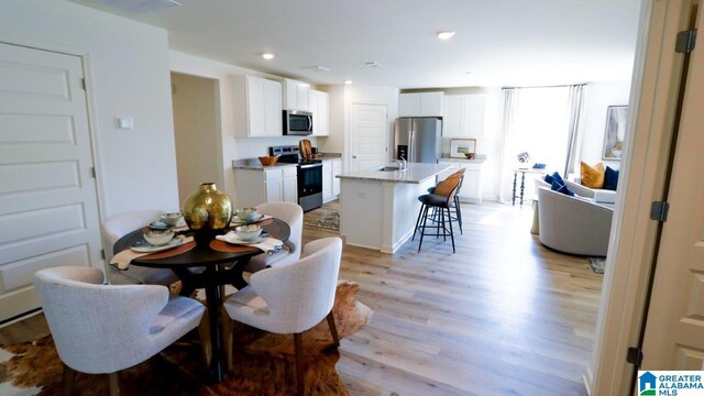 dining space featuring sink and light hardwood / wood-style floors