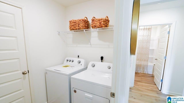 laundry room featuring light hardwood / wood-style floors and washer and dryer