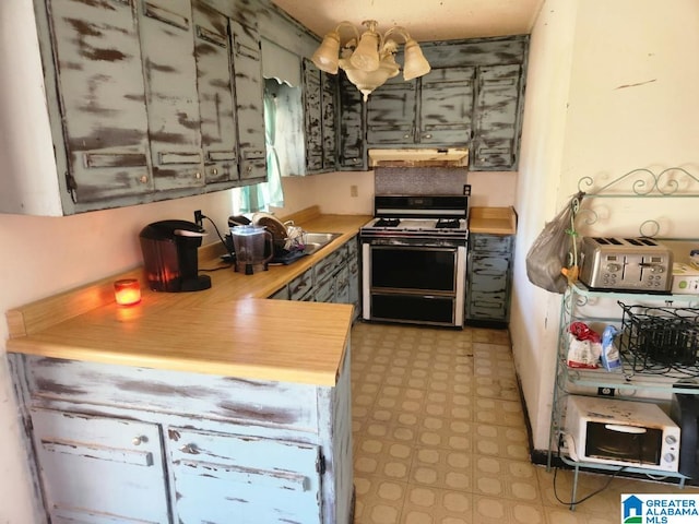 kitchen featuring sink, kitchen peninsula, and white range with gas stovetop