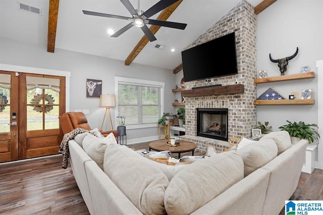 living room featuring a fireplace, ceiling fan, dark wood-type flooring, beam ceiling, and french doors