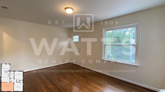 empty room with a healthy amount of sunlight and dark hardwood / wood-style flooring