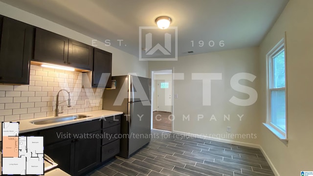 kitchen featuring tasteful backsplash, sink, and stainless steel refrigerator