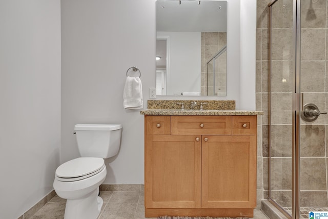 bathroom featuring vanity, tile patterned flooring, toilet, and walk in shower