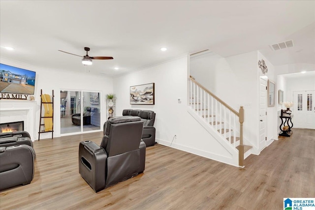 living room featuring crown molding, ceiling fan, and light hardwood / wood-style floors