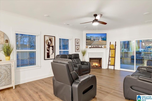 living room featuring ornamental molding, light hardwood / wood-style floors, and ceiling fan