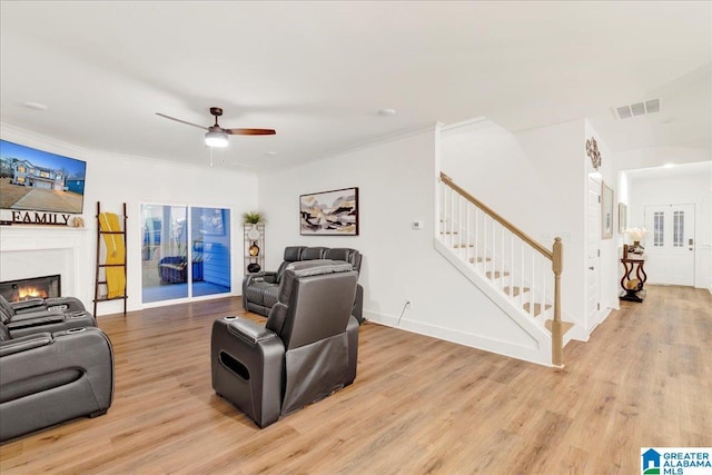 living room with ornamental molding, ceiling fan, and light hardwood / wood-style floors