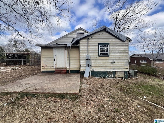 back of property with central AC unit and a patio