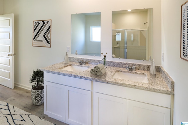 bathroom featuring vanity, hardwood / wood-style floors, and a shower with door