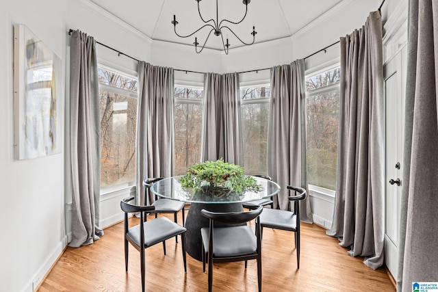 dining space with ornamental molding and light hardwood / wood-style floors