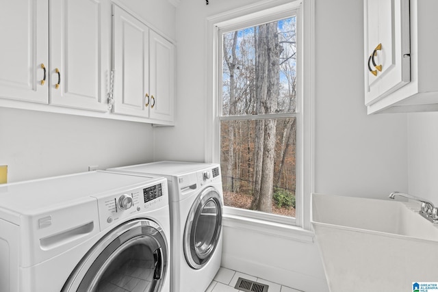 laundry area featuring light tile patterned flooring, cabinets, washer and clothes dryer, and sink