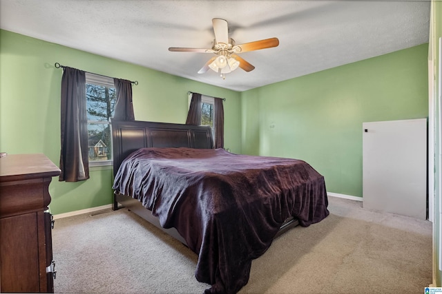 carpeted bedroom featuring ceiling fan and a textured ceiling