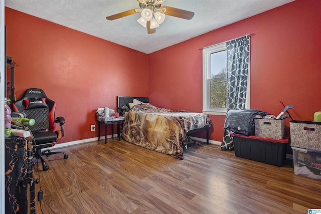 bedroom featuring a textured ceiling, wood-type flooring, and ceiling fan