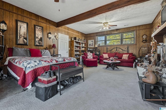 bedroom featuring carpet, a textured ceiling, beam ceiling, and wood walls