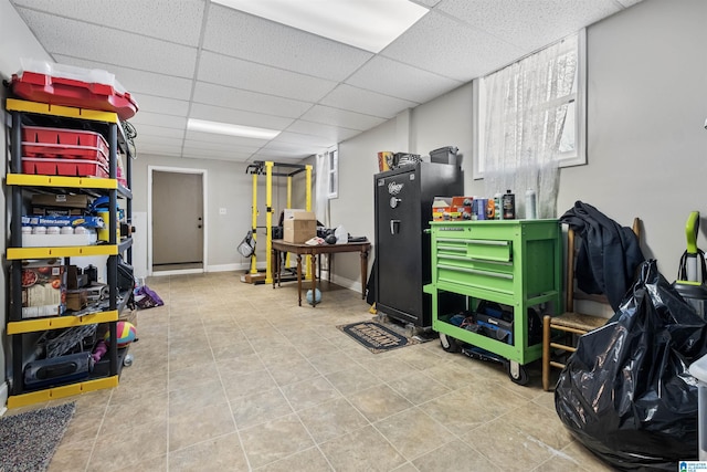 basement featuring a paneled ceiling and tile patterned floors