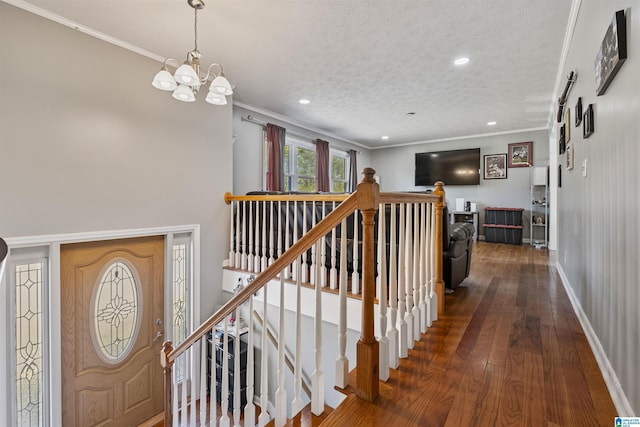 interior space featuring dark hardwood / wood-style flooring, crown molding, a textured ceiling, and an inviting chandelier